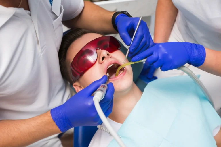 Patient receiving professional teeth cleaning from dental hygienist wearing gloves and protective eyewear in a Fairfield dental clinic