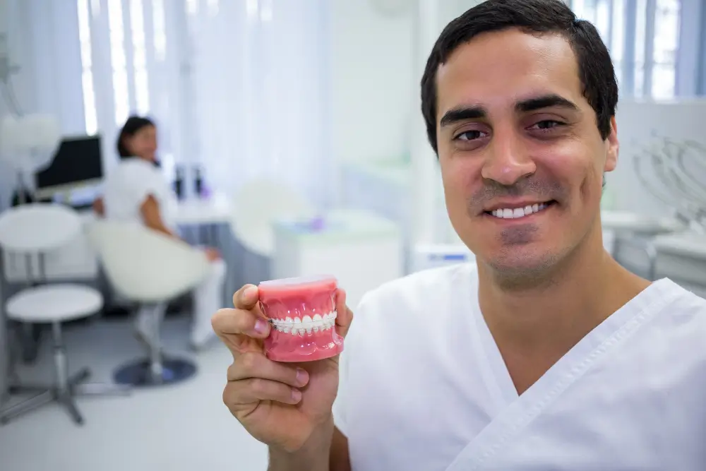 Patient holding fallen-out dental bridge needing same-day repair in Fairfield CA