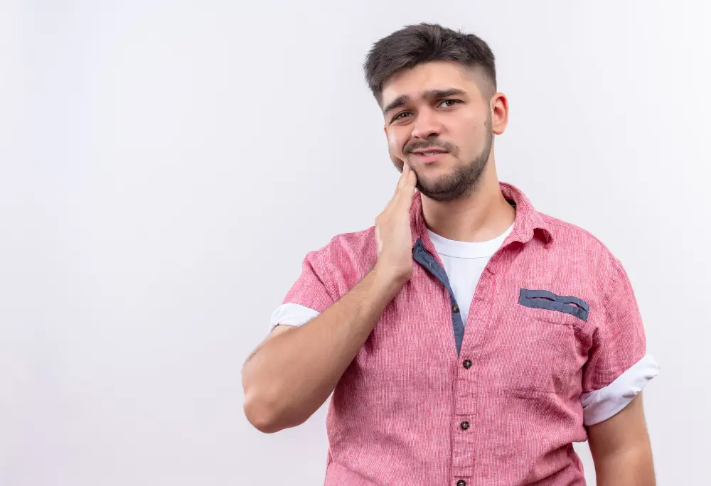 Patient with wisdom tooth pain holding jaw needing emergency treatment in Fairfield CA